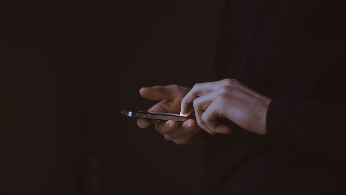 A person looking at a smartphone in a dark room, representing the struggle with digital addiction and the need for private recovery tools.