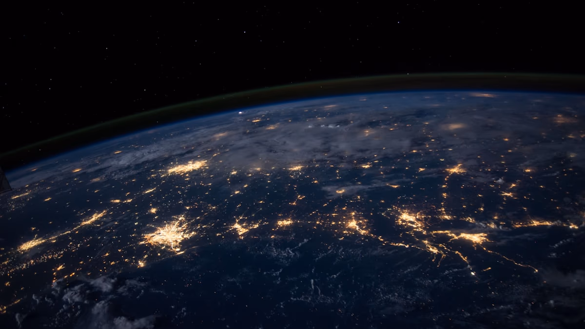 A vast cloud computing data centre at night with thousands of illuminated server racks stretching into the distance under a vaulted ceiling — representing the massive AWS infrastructure commitment at the heart of the Amazon-Anthropic $33 billion deal, which will deploy up to 5 gigawatts of custom Trainium AI compute for Claude model training and inference.