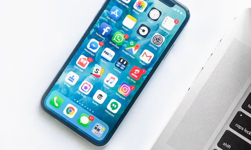 Smartphone on a dark reflective surface representing Apple's upcoming iPhone Fold 2026 foldable device entering trial production with 7.8 inch display and $2000 price point