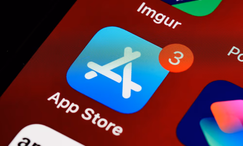 Smartphone showing the App Store with a blurred Apple logo in the background