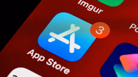 Smartphone showing the App Store with a blurred Apple logo in the background